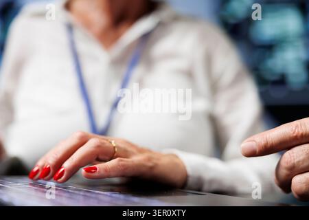 Data storage company executives working to maintain uptime in server hub. Hardworking admins brainstorming solutions to mainframes crashing, trying to fix components, close-up. Stock Photo