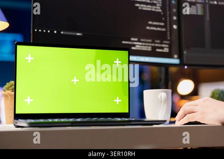 System administrator designing and developing software applications using green screen laptop. Stock Photo