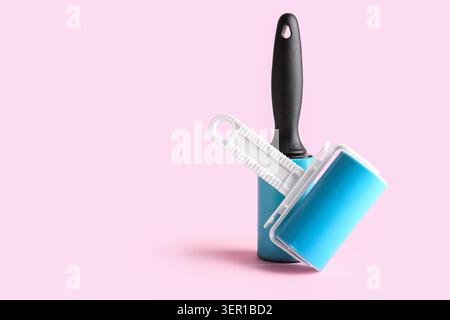 Different lint rollers on pink background Stock Photo
