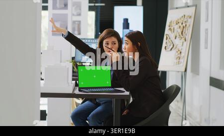 Team of architects working with green screen layout on PC, planning new building project for urban development, technicians developing new drafts for construction blueprints and sketches. Stock Photo
