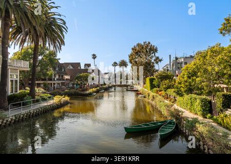 High-end residential houses and tall palm trees reflected in the calm water of the Venice Canals in California Stock Photo
