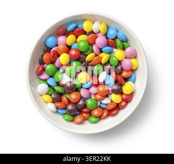 Colorful chocolate candy pills in bowl isolated on white background. Top view Stock Photo