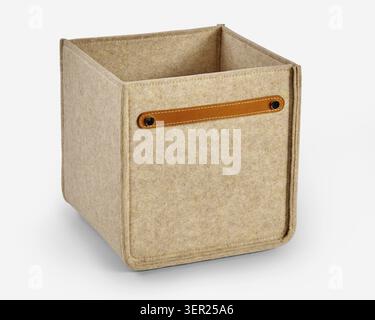 Empty beige felt storage box with brown leather handle, promoting organization and minimalist design Stock Photo