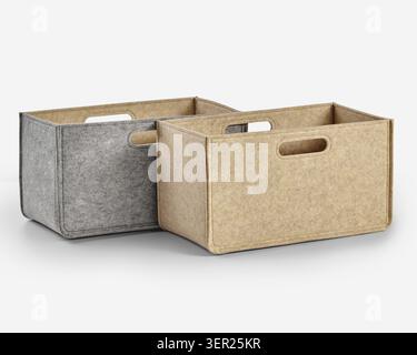 Two empty rectangular felt storage boxes in gray and beige, featuring integrated handles, ideal for organizing and decluttering Stock Photo