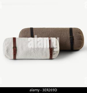 Two soft, cylindrical bolster pillows with leather straps lie on a minimalist white surface, creating a cozy and stylish atmosphere Stock Photo