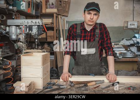 Carpenter working with a chisel and hammer in a wooden workshop Stock Photo