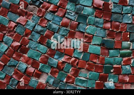 Red and green squares create rhythmic patterns. Texture is rough yet vibrant and ancient. Perfect for design, art, or historical themes Stock Photo