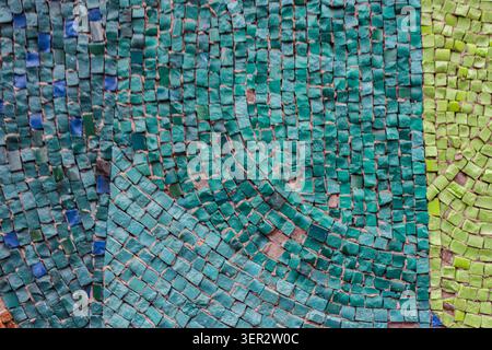 Colors range from deep teal to soft sage green. Each tile contributes to a cohesive, abstract design. Surface shows slight wear, adding character Stock Photo