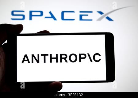 In this photo illustration, an Anthropic logo is seen displayed on a smartphone with a Space X logo in the background. Stock Photo