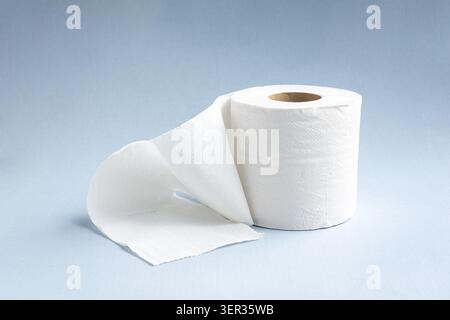Toilet paper roll on light blue background. Stock Photo
