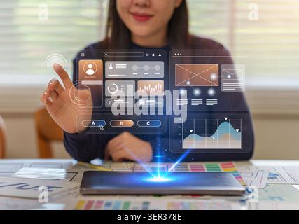 Asian female designer interacting with holographic user interface for app development Stock Photo