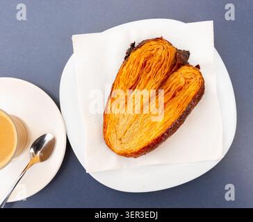 Puff pastry cookies shaped like ears on plate, served with hot cocoa Stock Photo