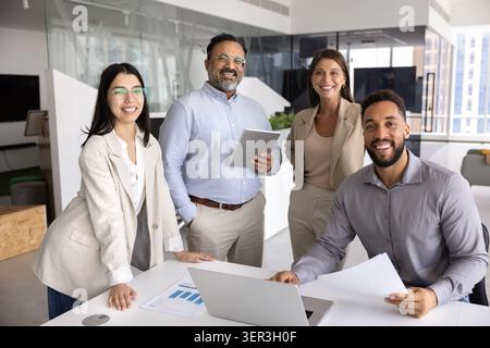 Group of confident four professionals posing together in office Stock Photo