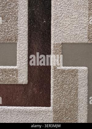 Close-up of a textured surface featuring raised rectangular and step-like shapes in neutral beige and brown tones. The composition shows a repeating g Stock Photo