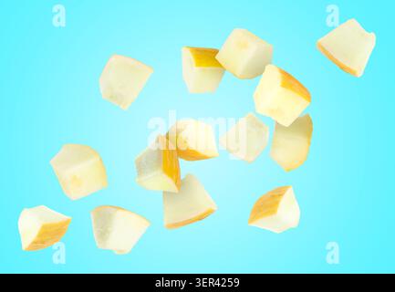 Sweet melon pieces flying in air against light blue background Stock Photo