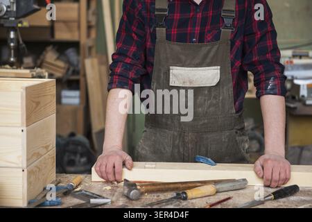 Carpenter working with a chisel and hammer in a wooden workshop Stock Photo