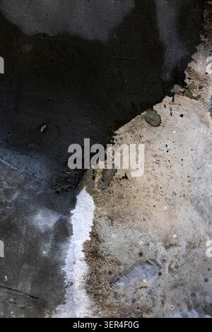 Water Stains On Concrete Surface. Abstract view of damp marks and moisture patterns on gray cement floor, suitable for industrial textures or architec Stock Photo
