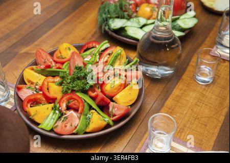 Multi-colored fresh cutted vegetables on a wooden plate Stock Photo