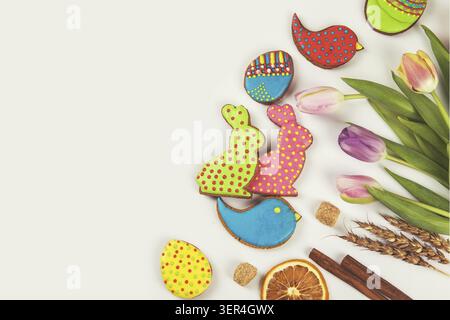 Tulips and gingerbread cookies on white background for Easter Stock Photo