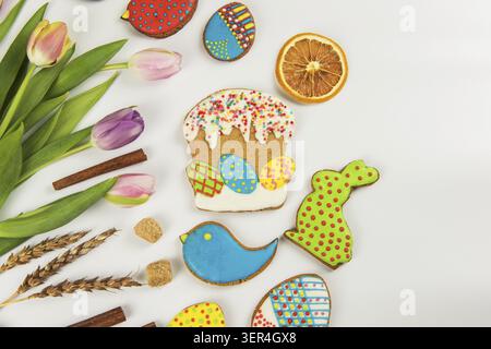 Tulips and gingerbread cookies on white background for Easter Stock Photo