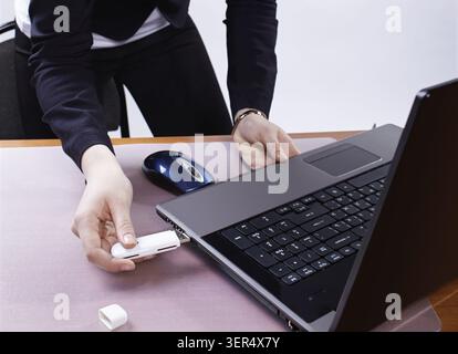 Girl's hand inserting usb flash memory into laptop header Stock Photo