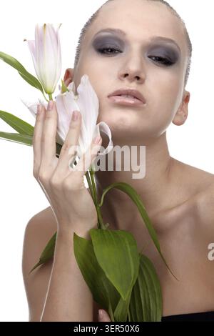 Portrait of beautiful dark haired slavonic model posing with flower Stock Photo