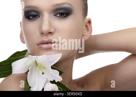 Portrait of beautiful dark haired slavonic model posing with flower Stock Photo