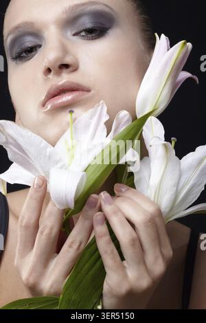 Portrait of beautiful dark haired slavonic model posing with flower Stock Photo