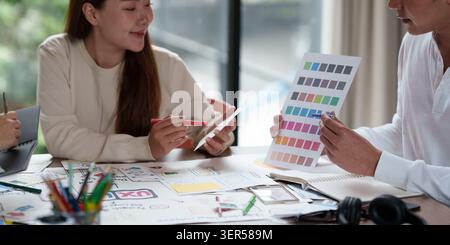 Asian creative designers collaborating on color palette selection for UX UI design Stock Photo
