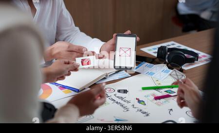 Creative design team prototyping mobile app interface with smartphone and paper mockups Stock Photo