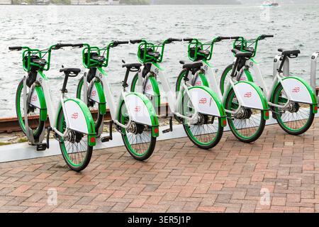 Row of green & white rental bicycles parked at Bergen Bysykkel station by the water in Bergen, Norway Stock Photo