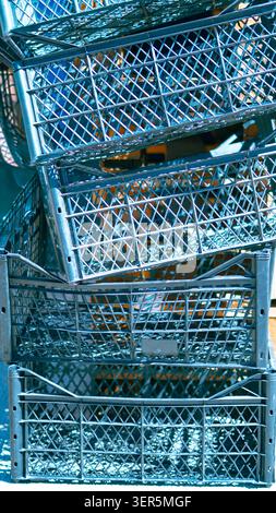 Stack of dark blue plastic crates for fruits and vegetables closeup. Stock Photo