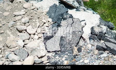 Pieces of broken asphalt and stones pile at construction site closeup. Stock Photo