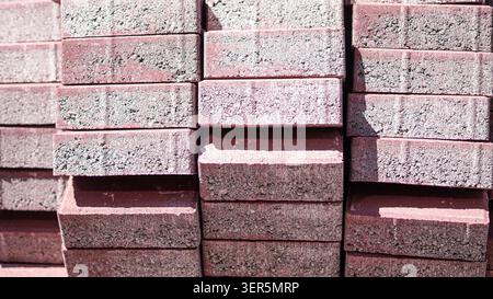 Red concrete paving stones stacked at construction site closeup. Stock Photo