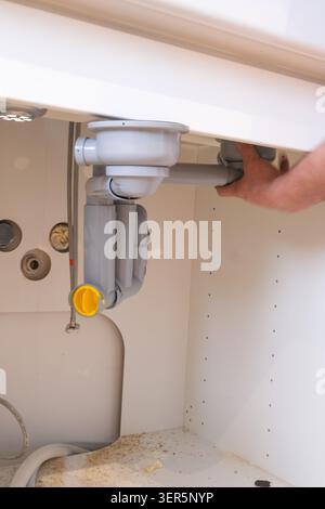Under-sink plumbing installation with trap and drain connection Stock Photo