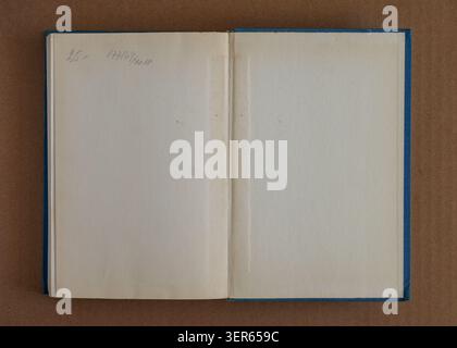 Open old book pages texture with blank aged paper, spine crease, blue cover edges, handwriting, stains. Natural background for book texture Stock Photo