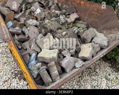 Container full of construction debris and old paving stones for recycling Stock Photo