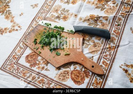Chopping Fresh Parsley on a Wooden Cutting Board Stock Photo
