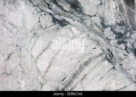 Close view of a marble surface showing white and grey patterns with natural veins and texture. Stock Photo