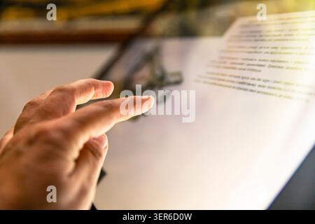 Woman using interactive touchscreen information display in modern museum exhibition hall indoors Stock Photo