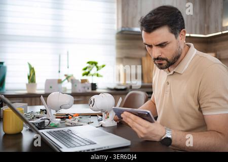 Technician configuring ip cameras using smartphone and laptop Stock Photo