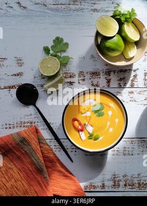 Vertical food composition featuring creamy pumpkin soup on rustic white wooden background Stock Photo
