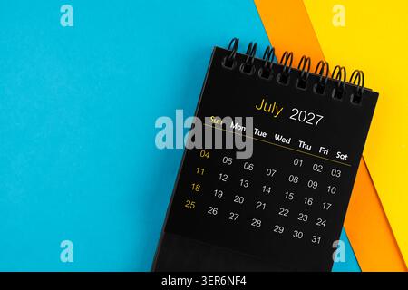 A Black calendar for July 2027 on multi color background. Stock Photo