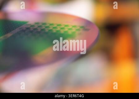 Silicon wafer surface with microchip patterns reflecting vibrant colors and zen bokeh Stock Photo
