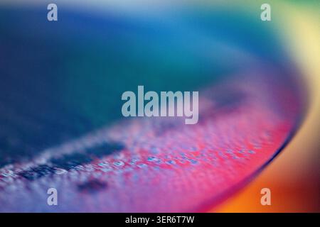 Circular silicon wafer surface showing intricate circuits in vibrant blue and magenta hues Stock Photo