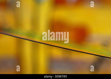 Abstract details of a silicon wafer highlighting its edge against a blurred yellow background Stock Photo
