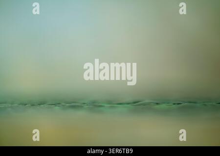 Abstract green liquid or fabric line flowing horizontally on a soft light background Stock Photo