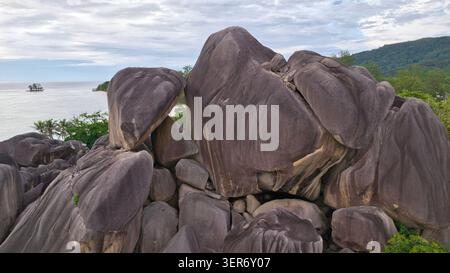 Impressive drone view showcasing a massive pile of iconic granite stone formations overlooking the ocean coast at the famous Anse Source d'Argent beac Stock Photo