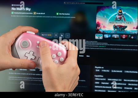 New York, USA - May 18, 2026: Playing No man's sky PC game with gamepad controller in hand close up view on screen background Stock Photo