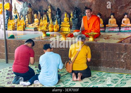 People praying in front of a Monk at shrine at Nat Preah ang Thom Phnomaul at 16th century Buddhist monastery in Phnom Kulen National Park Cambodia Stock Photo